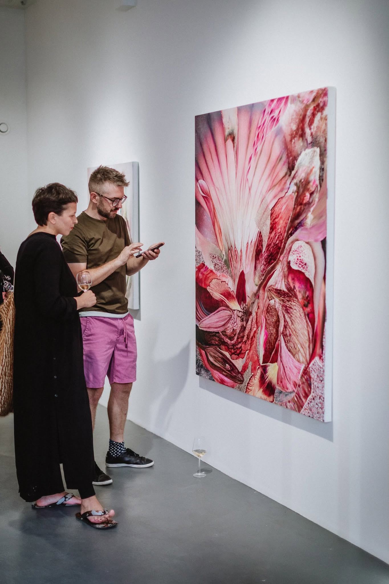 Visitors considering a large artwork in the gallery